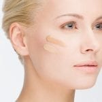 close-up portrait of young beautiful woman with cosmetic foundation