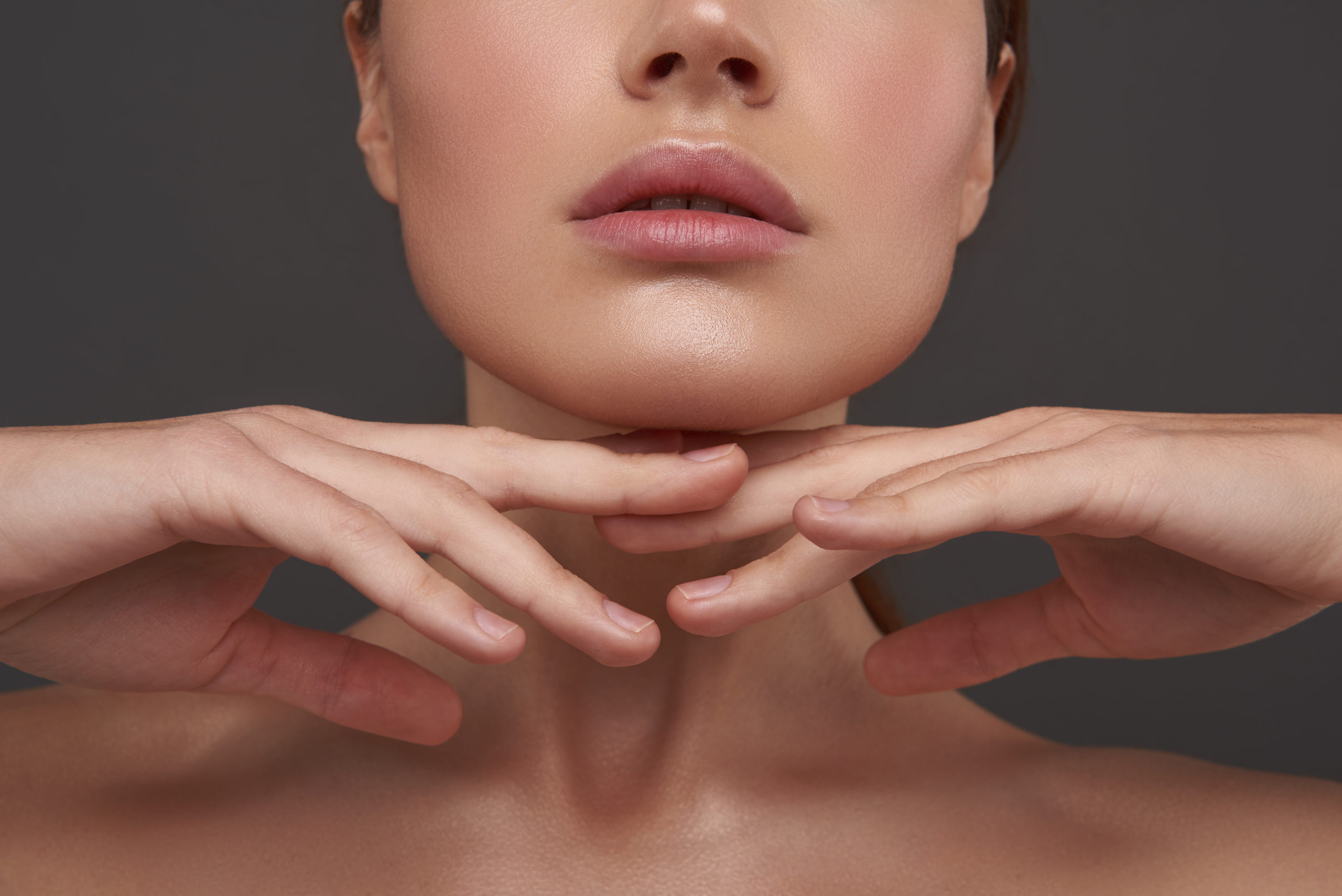 Beautiful young woman with perfect skin keeping hands under her chin Hand Rejuvenation in Pflugerville, TX